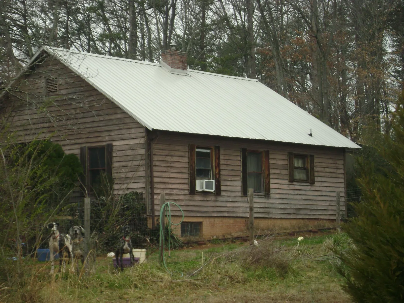 White metal roof on an old wood sided farmhouse, from a Metal Roof Installation job in Manning